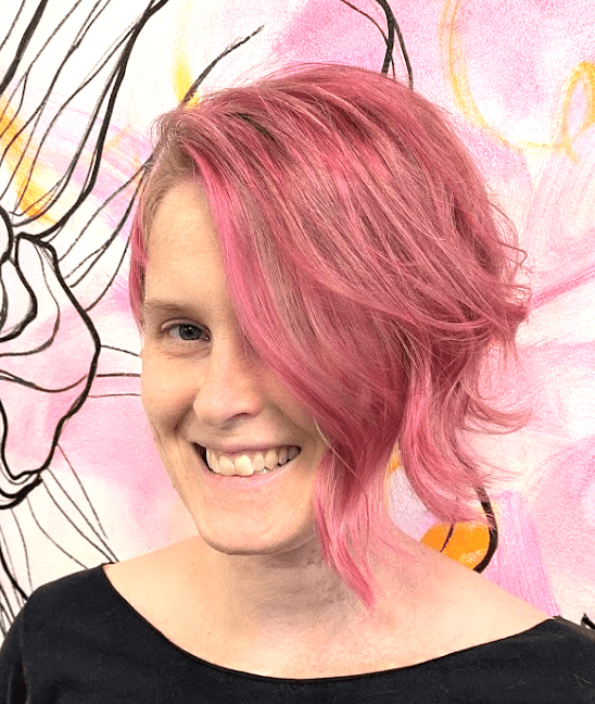smiling white femme with pink hair
